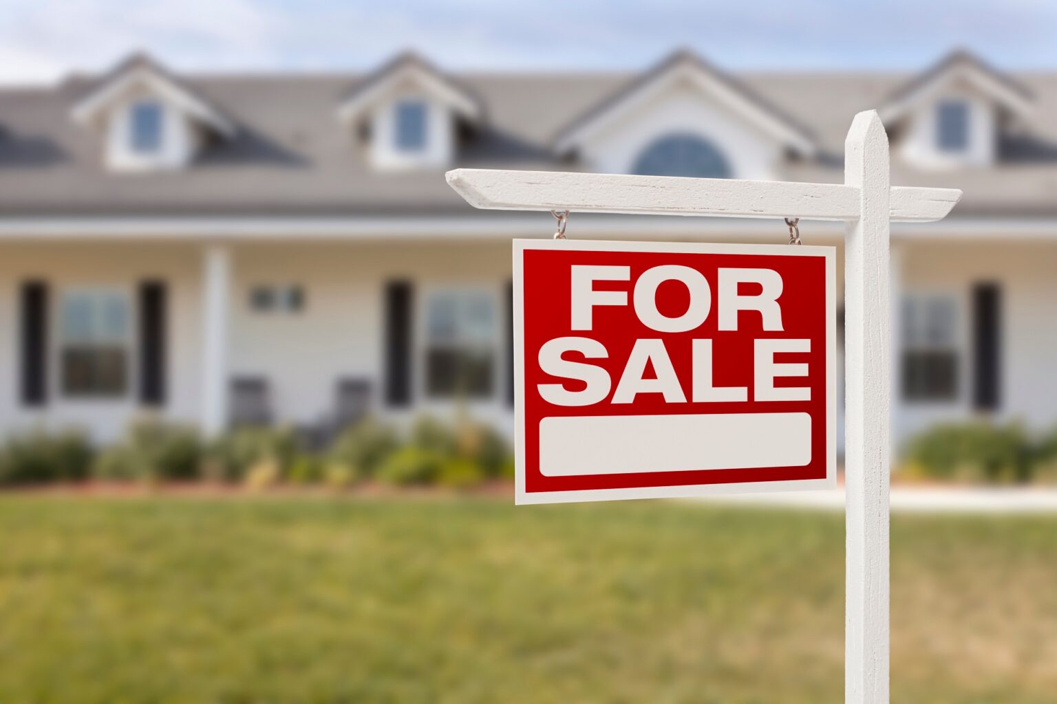 Red For Sale Real Estate Sign in Front of Beautiful New Home.